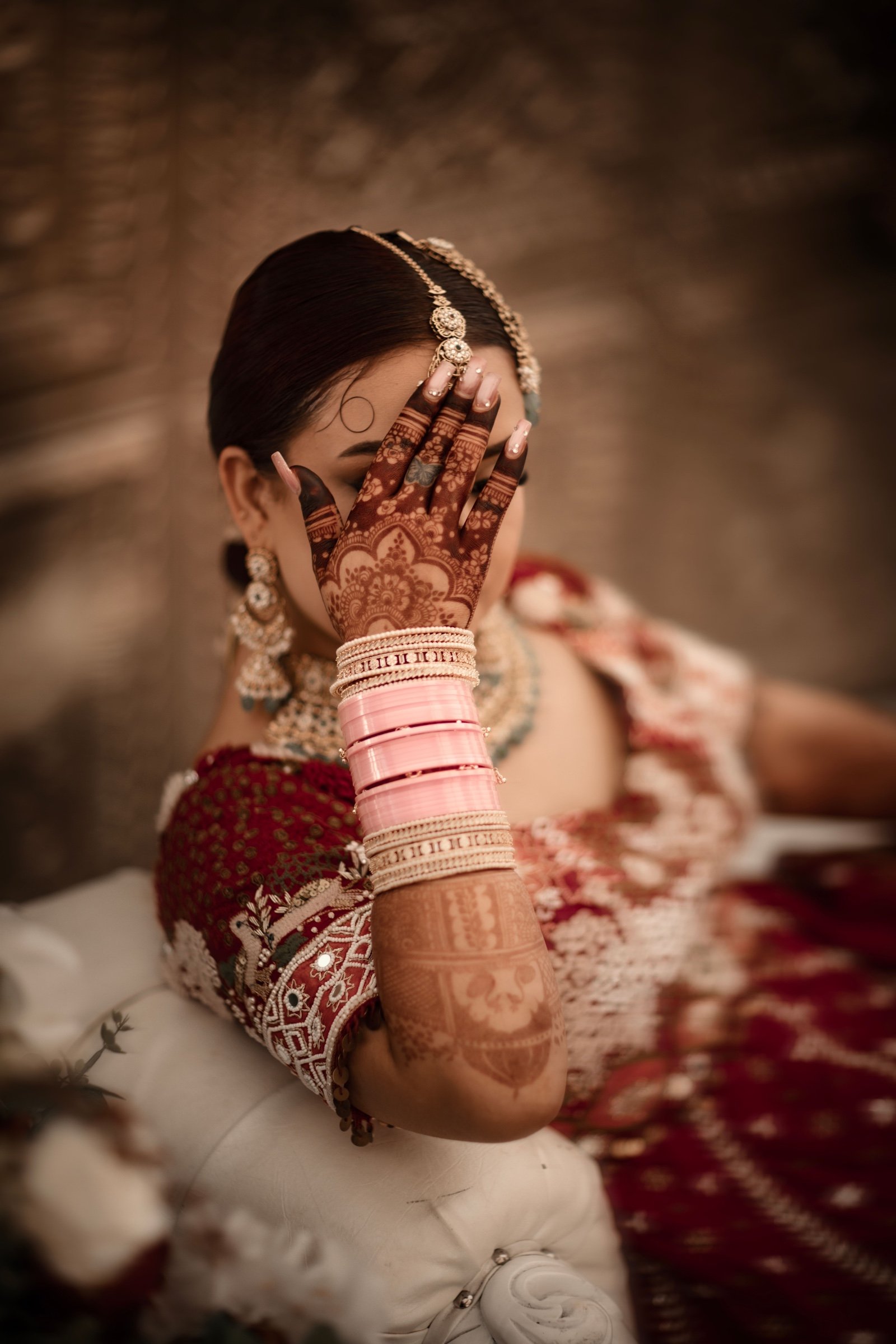 Bride hiding a smile behind her henna-painted hand
